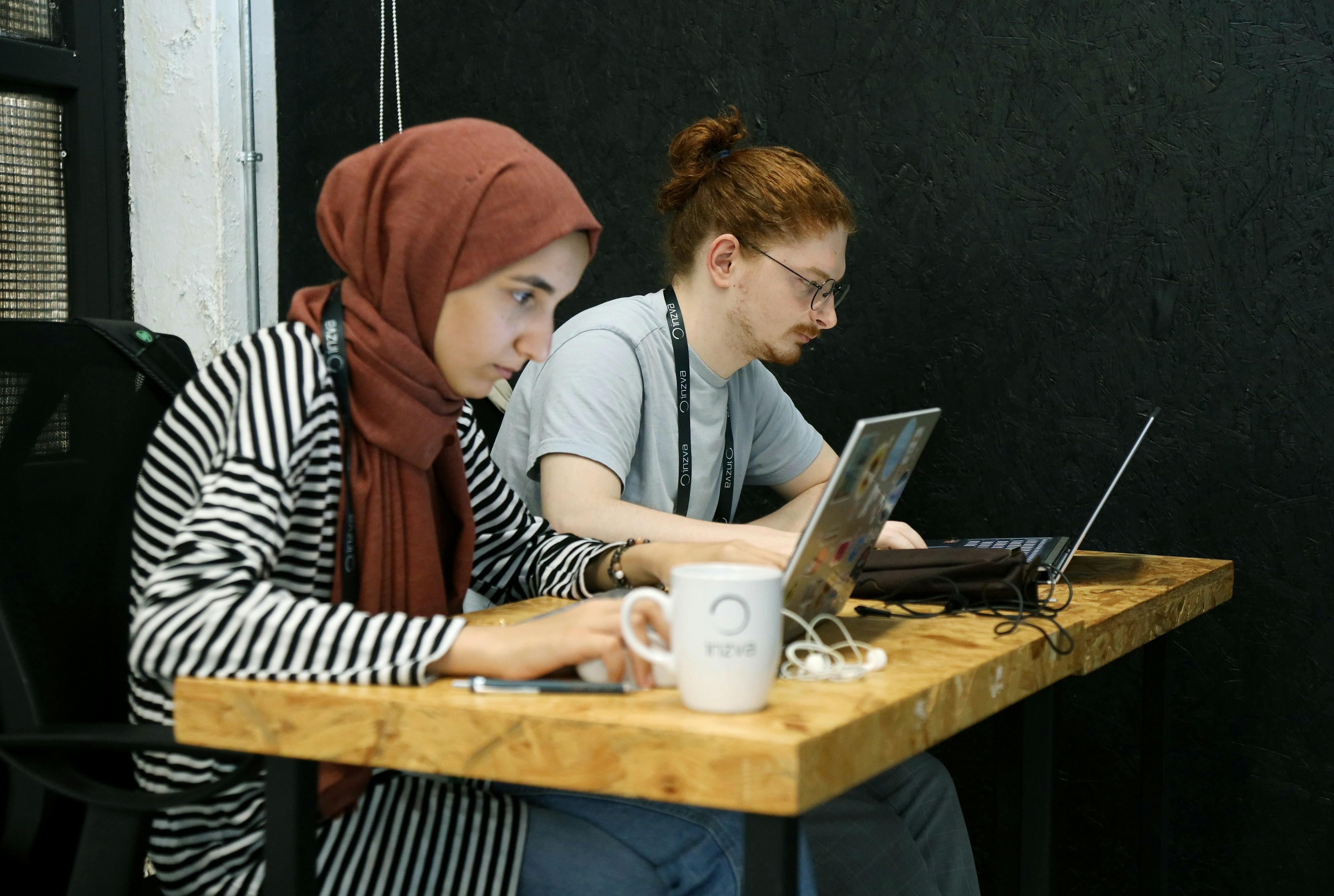 Two students working side by side on laptop computers