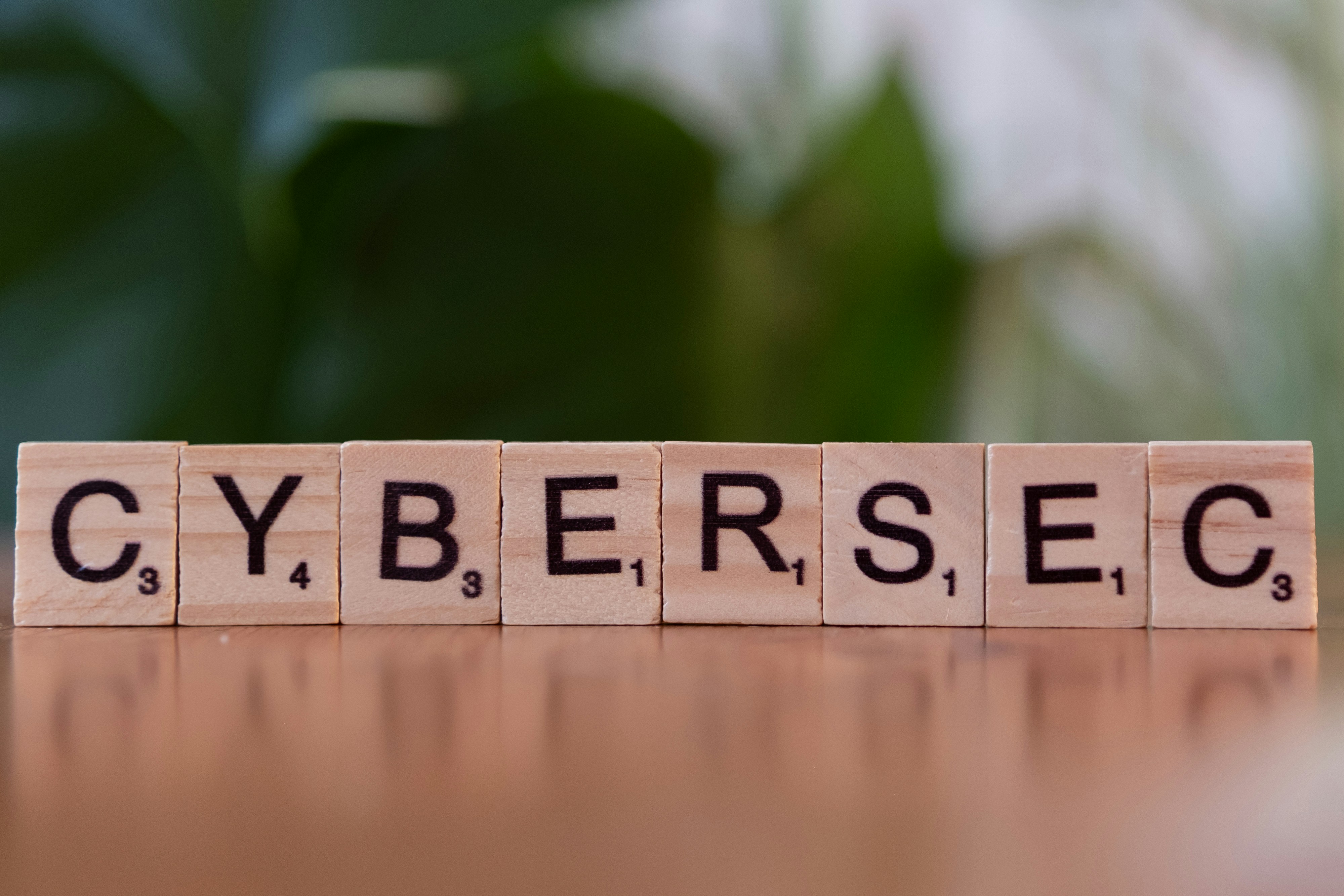 Wooden letter tiles spelling CYBERSEC on a table